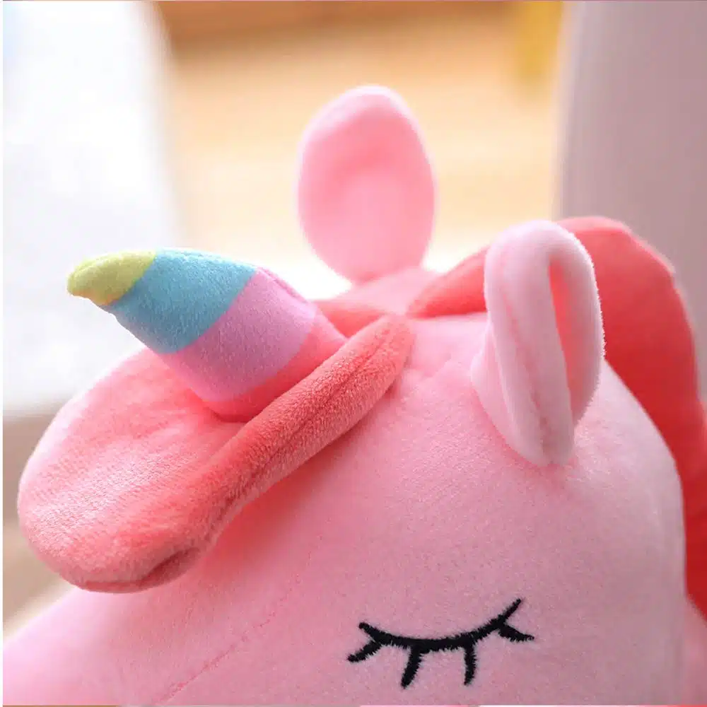 PELUCHE LICORNE LUMINEUSE ROSE AILÉE 6 PELUCHE LICORNE LUMINEUSE ROSE AILÉE VU DE LA TÊTE DE TRÈS PRÊT