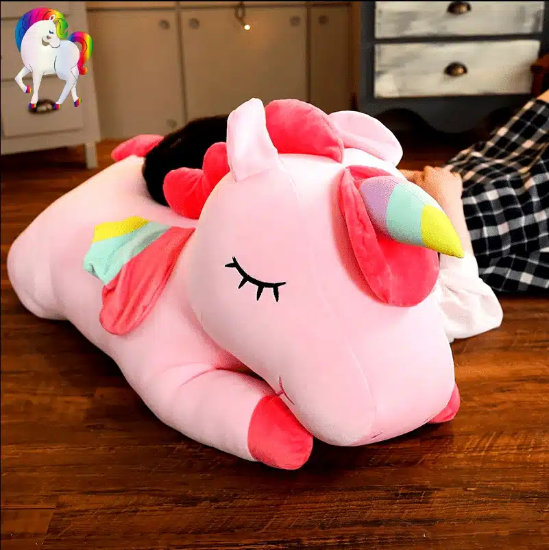 PELUCHE LICORNE GÉANTE ROSE AILÉE 6 JEUNE FILLE QUI DORT SUR UNE PELUCHE LICORNE GÉANTE ROSE AILÉE